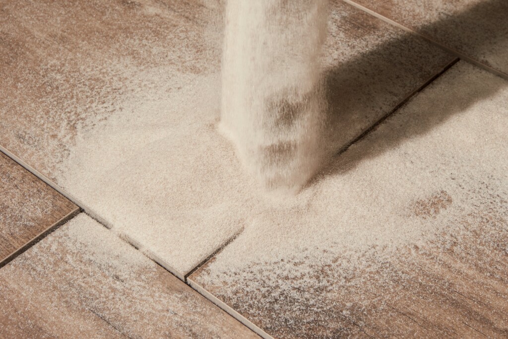 Fugensand wird auf Keramikplatten gesch&uuml;ttet